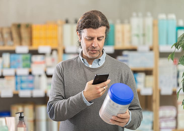 A man scanning a baby food's information while shopping.