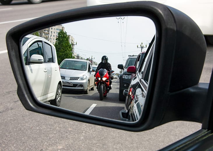 A red, sporty, motorcycle moves between the lanes.
