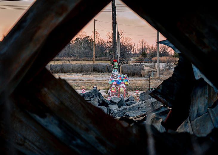 View of Christmas decorations in a parade amongst debris with a sunset in the background in Picher, Oklahoma, a town left abandoned after it was designated a superfund site due to contamination with mining waste.