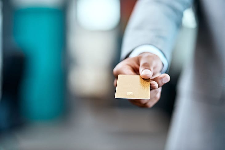 A businessman handing a credit card for payment.