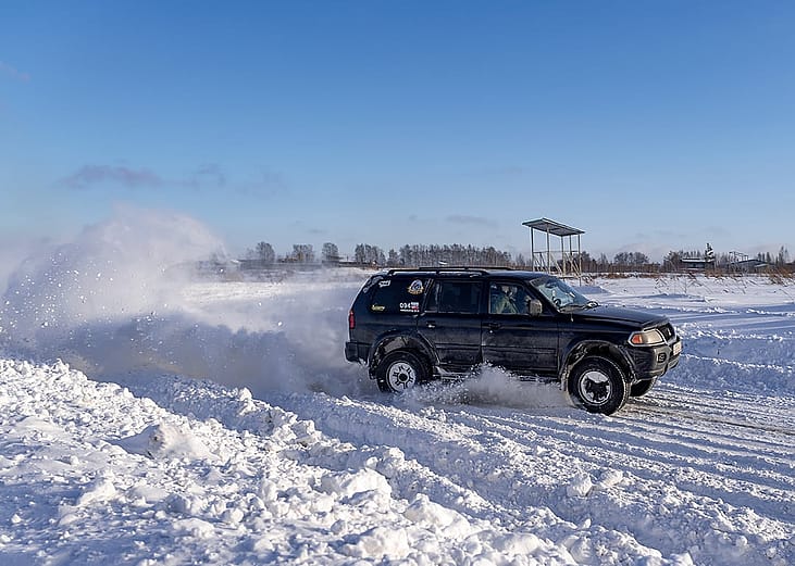 A 4x4 all-wheel drive-modified SUV on the road during heavy winter.
