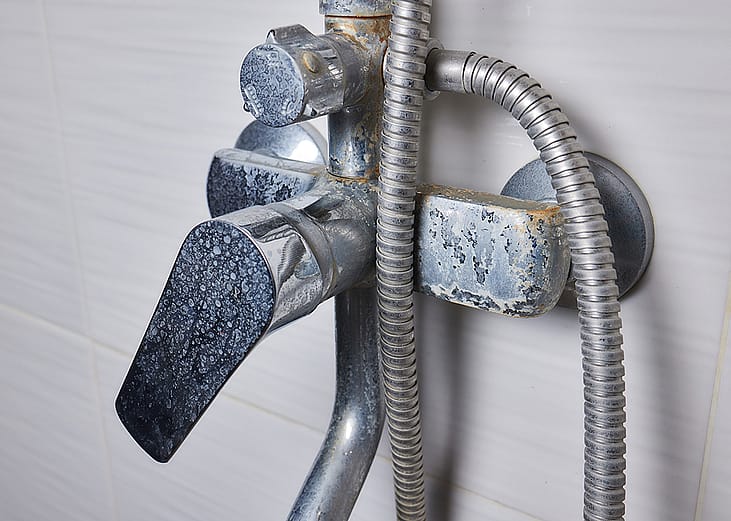An old tap aerator with marks of hard water.