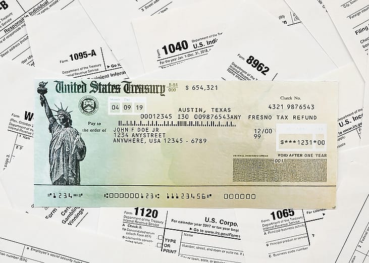 A US Treasury refund check on top of tax forms.