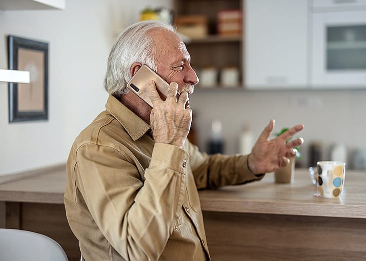 A happy senior man talking on the phone.