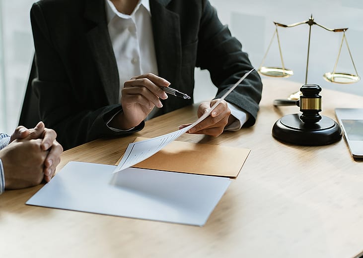 A legal counsel presenting a contract to a client in a law office.