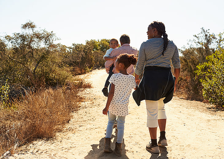 Grandparents walking outdoors with their grandchildren.