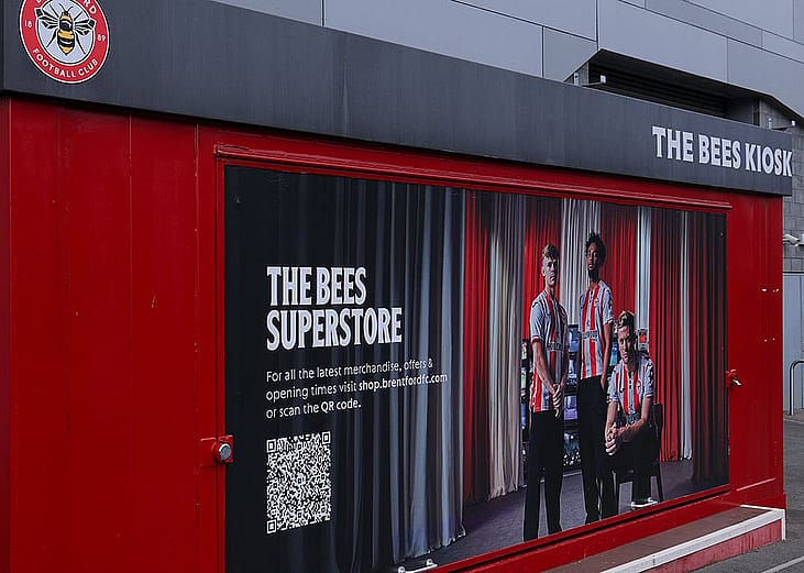 A Brentford Football Club merchandise kiosk promoting The Bees superstore with a QR code in London, United Kingdom.