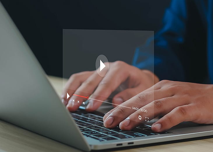 Graphic of a YouTube video screen over a person using a laptop.