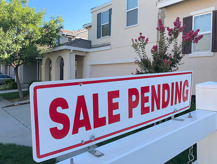 A sale pending sign in front of a house.
