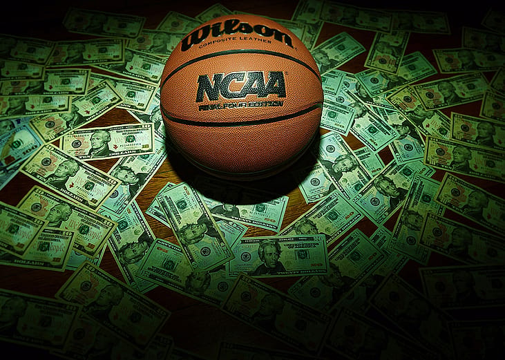 An NCAA Final Four Edition basketball surrounded by banknotes.