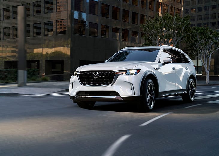 A white Mazda CX-90 on the road.
