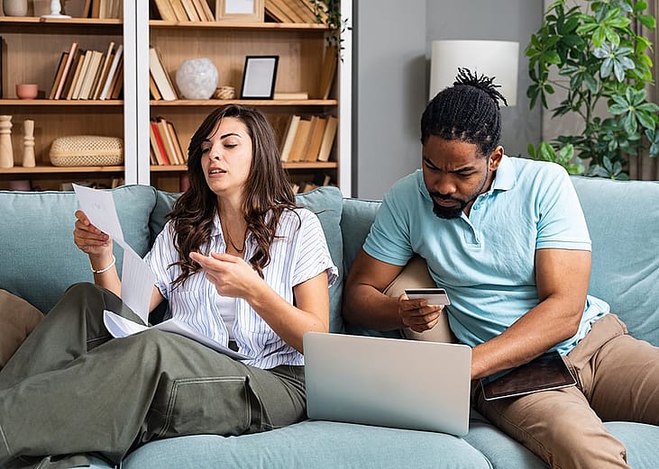 A couple at home stressfully reviewing household bills.