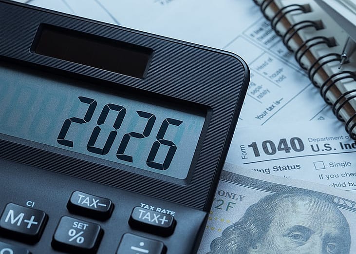 '2026' on a calculator over tax forms.