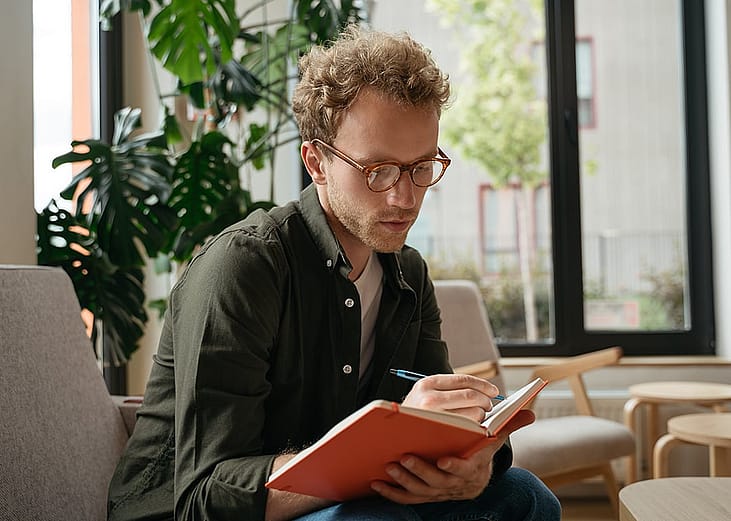 A person taking notes while working in an office.