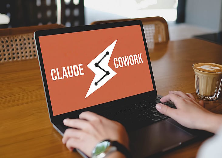 A person using the Claude Cowork platform while working at a cafe.