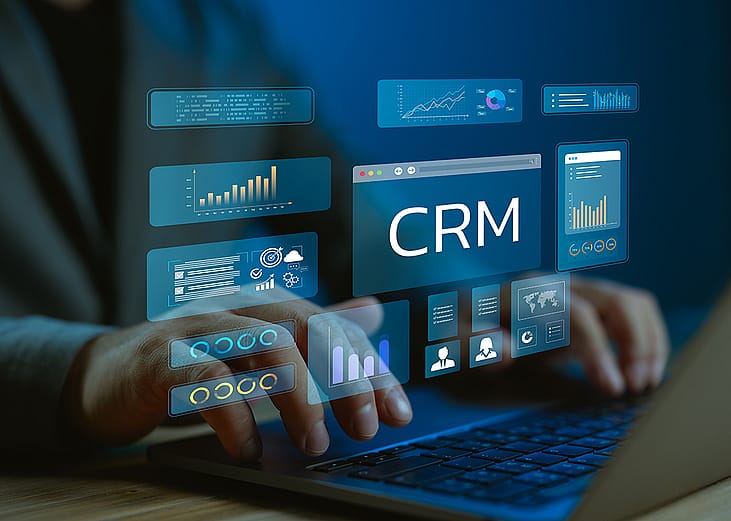 A data analyst utilizing CRM (Customer Relationship Management) system and dashboard from a work laptop.