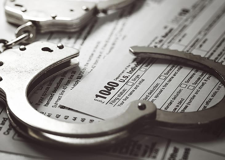 Handcuffs over U.S. tax 1040 forms.