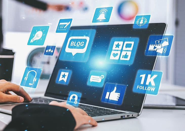 Blogging and engagement graphics illustrated over a laptop.