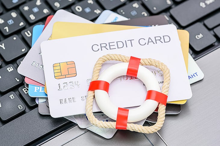 A small red lifebuoy on top of credit cards.