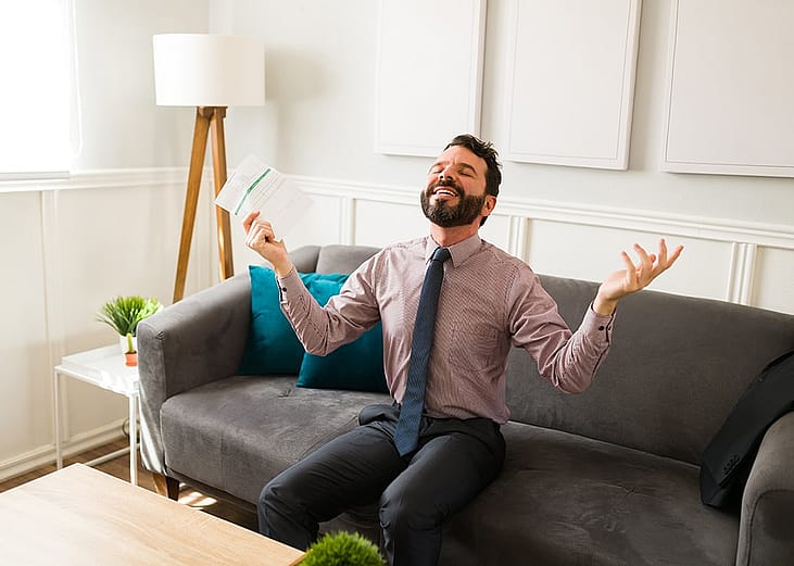 A businessman feeling free and happy while holding financial document.