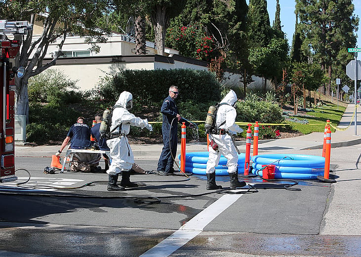 Hazardous materials team cleaning up a truck and chemicals accident on the road.