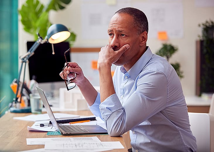 A businessman in deep thought while working in an office.