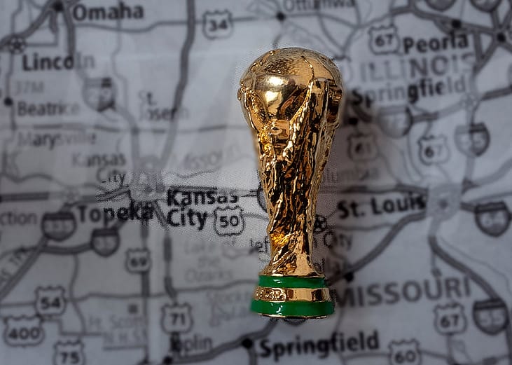 A miniature golden FIFA World Cup trophy on top of a map focused on Kansas City where the 2026 games will be held.