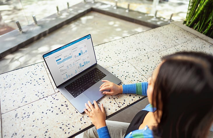 A person checking financial graphs and charts from a laptop.