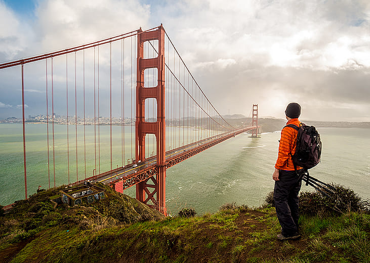 A hiker-traveler looking at the famous Golden Gate Bridge in San Francisco, USA.