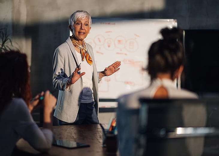 A female senior executive leading a team meeting.
