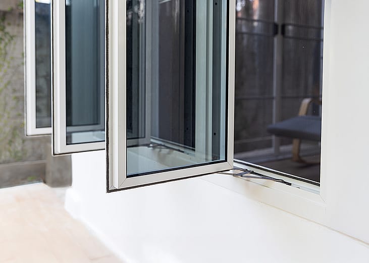 Three panel aluminum casement window installed in a home wall. 