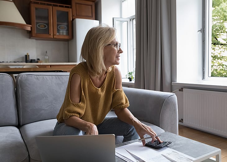A female homeowner in deep thought while calculating home expenses.