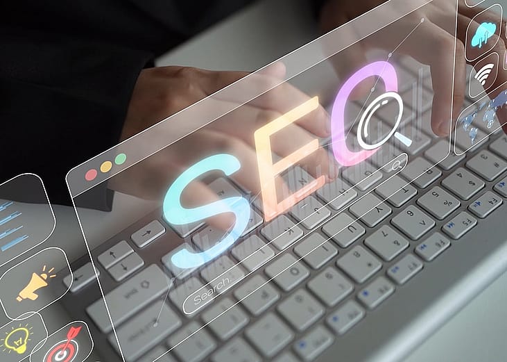 Holographic SEO concepts over a focused person using a keyboard.