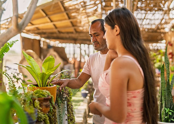 A couple checking and purchasing plants at a local garden store.