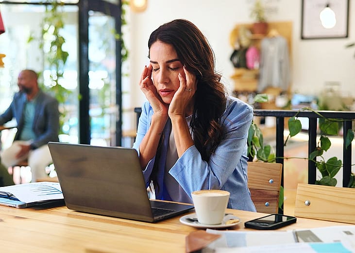 A female professional experiencing headache while working.