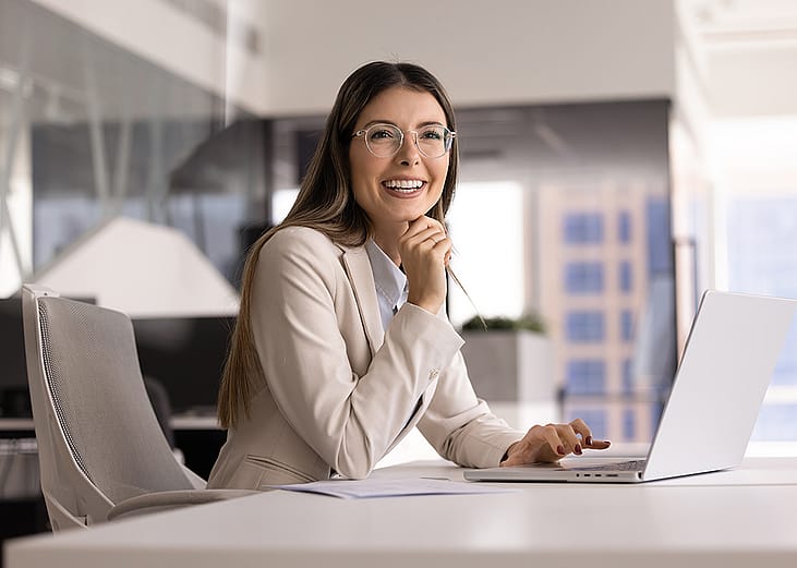 A female business executive happily looking at a presentation in an office.