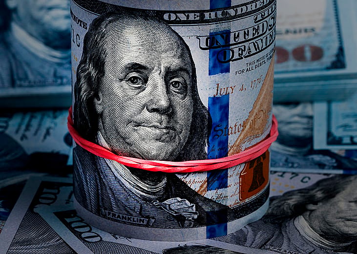 Close up on a rolled band of US dollar banknotes.