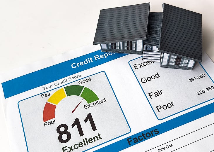 A small figure of a house on top of a credit score report.
