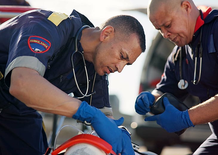 Paramedics attend to a road accident victim.