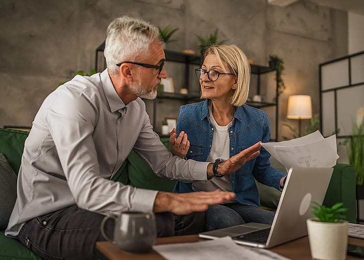 An elderly couple discussing over their estate plan's documents at home. 