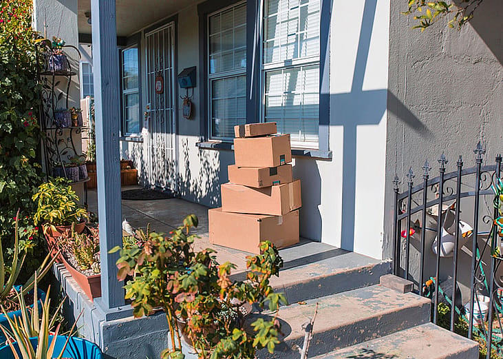 Delivery packages piled up on a front porch.