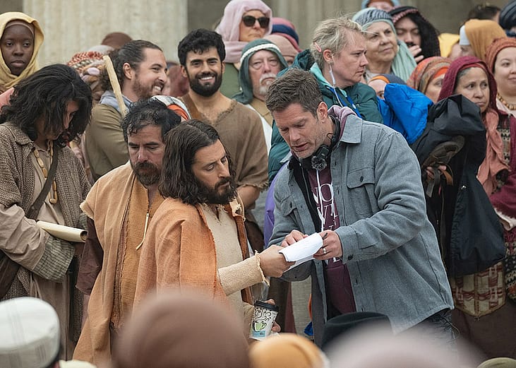 Directory Dallas Jenkins on set surrounded by actors dressed in costume for a scene of season 5 of The Chosen.