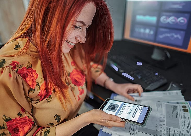 A woman scans a QR code with a smartphone.