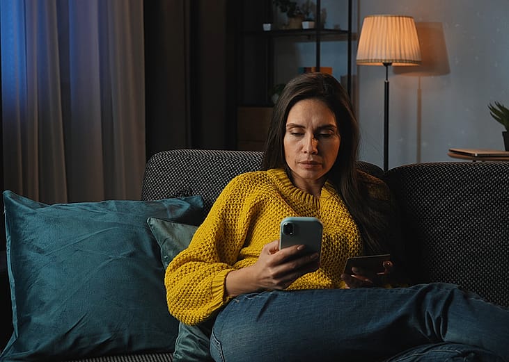 A middle-aged woman at home purchasing online using her credit card.