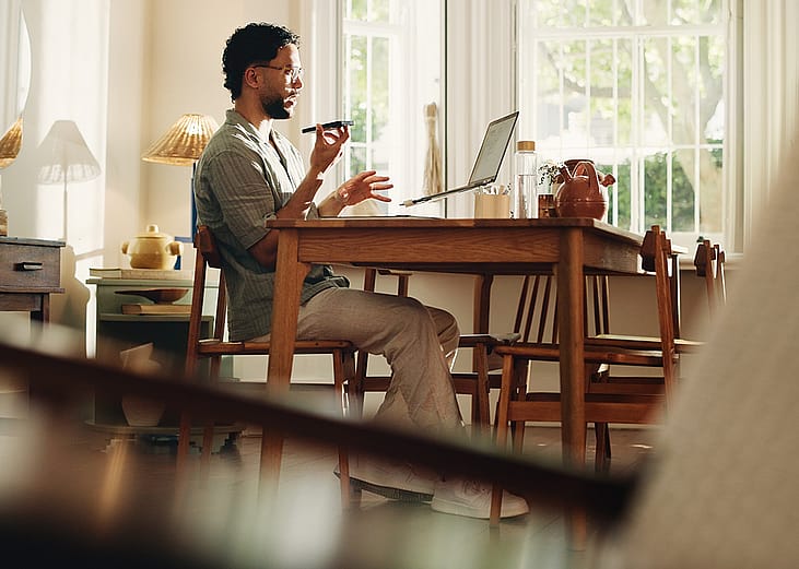 A businessman working from home and talking on the phone.
