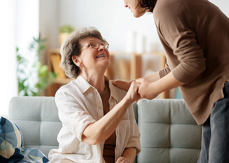 An elderly patient with her caregiver sharing a conversation with each other.