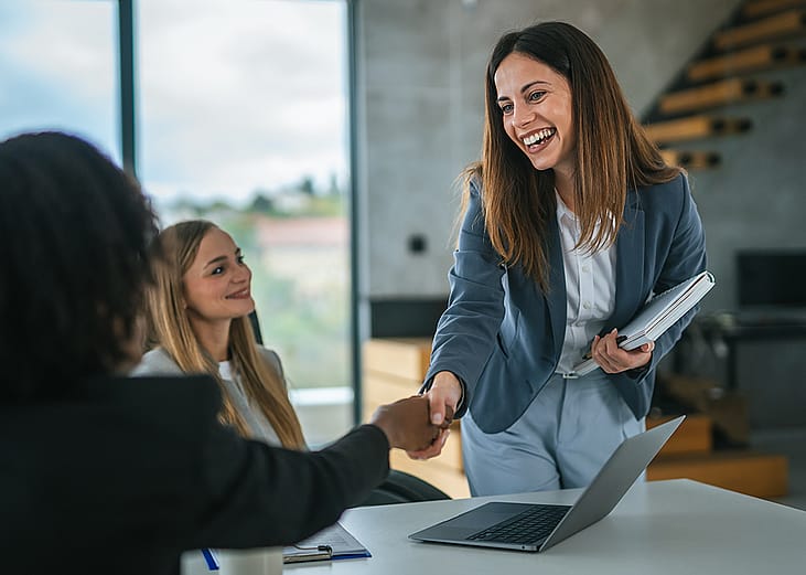 Two businesswomen concluding a meeting with a handshake.