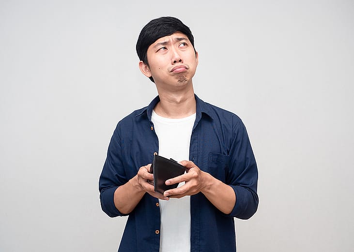 A frugal man confusingly holding an empty wallet.