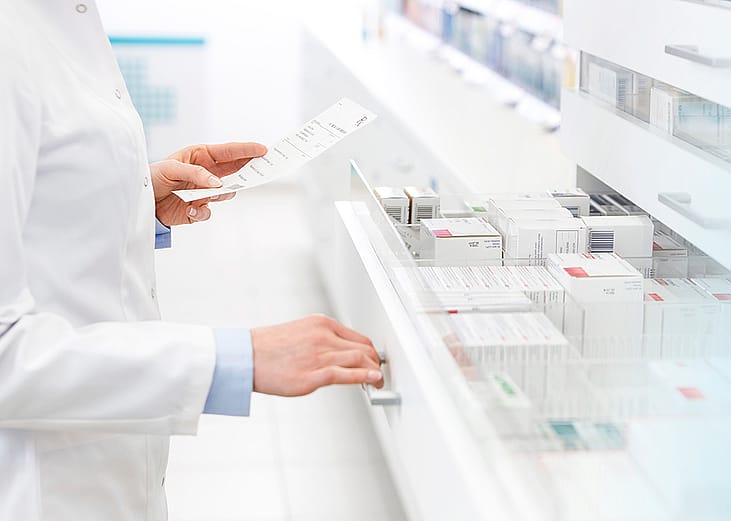 A pharmacists filling out a prescription in a pharmacy.