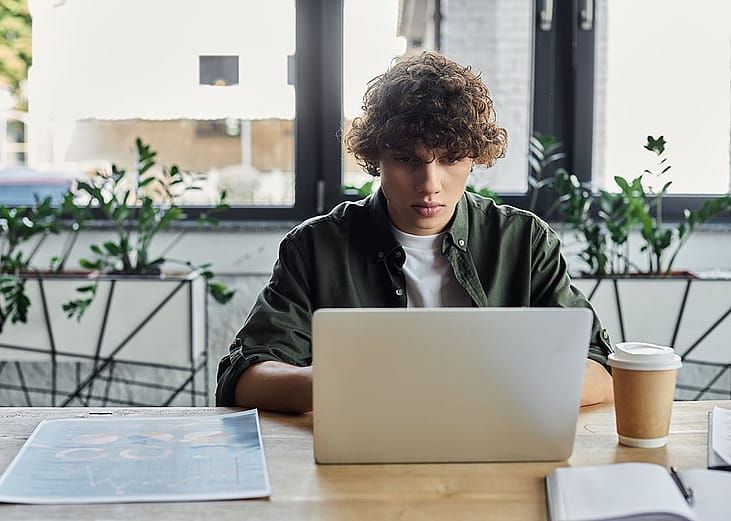 A young man working with a laptop in a stylish office.